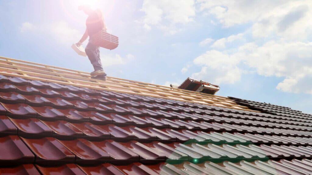 A man standing on top of a roofing structure.