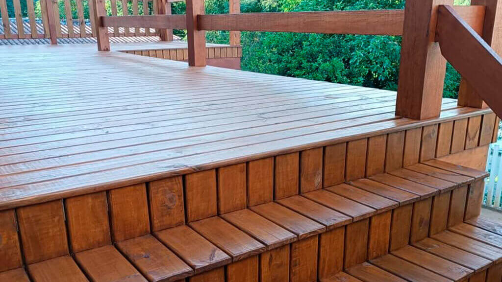 wood deck with a wood stair, wood fence,and trees in the background.