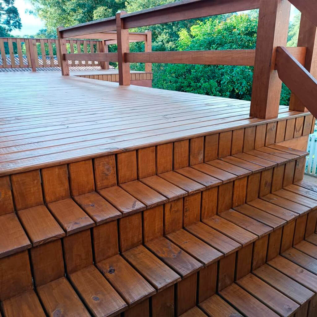 wood deck with a wood stair, wood fence,and trees in the background.