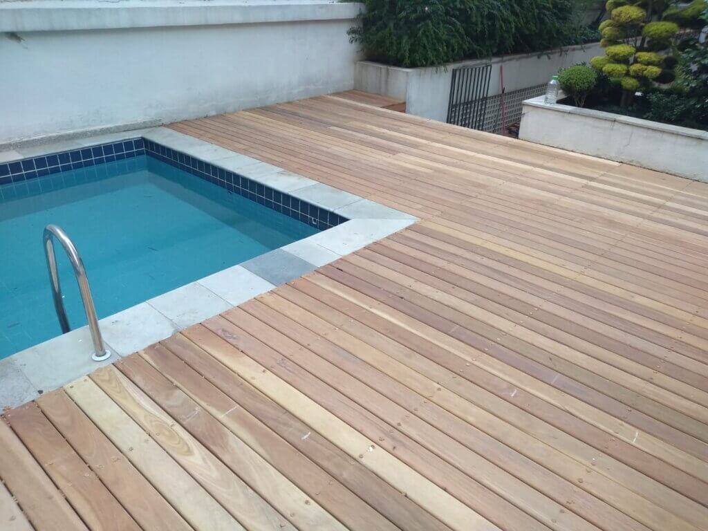 wood deck with a pool on the left side.