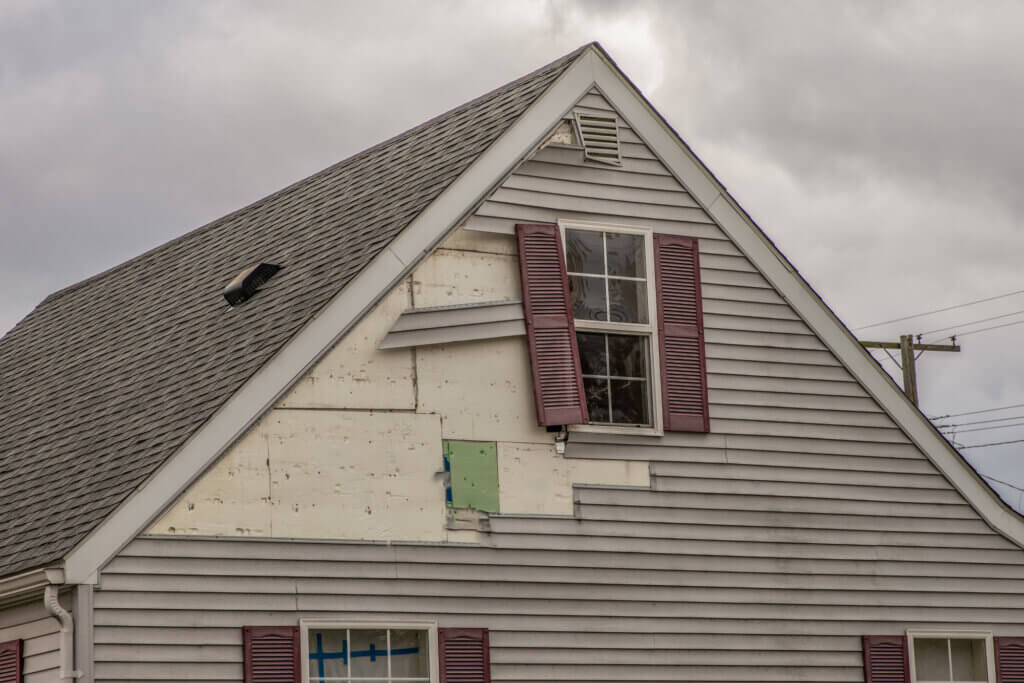 A house with a broken gray siding.