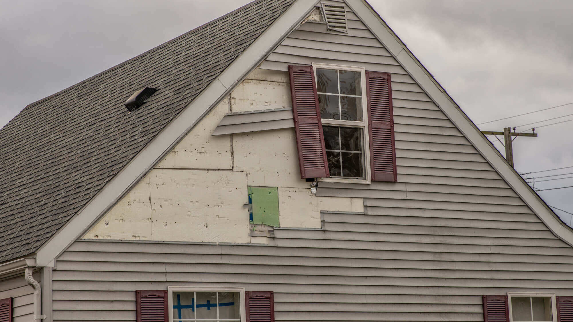 A house with a broken gray siding.