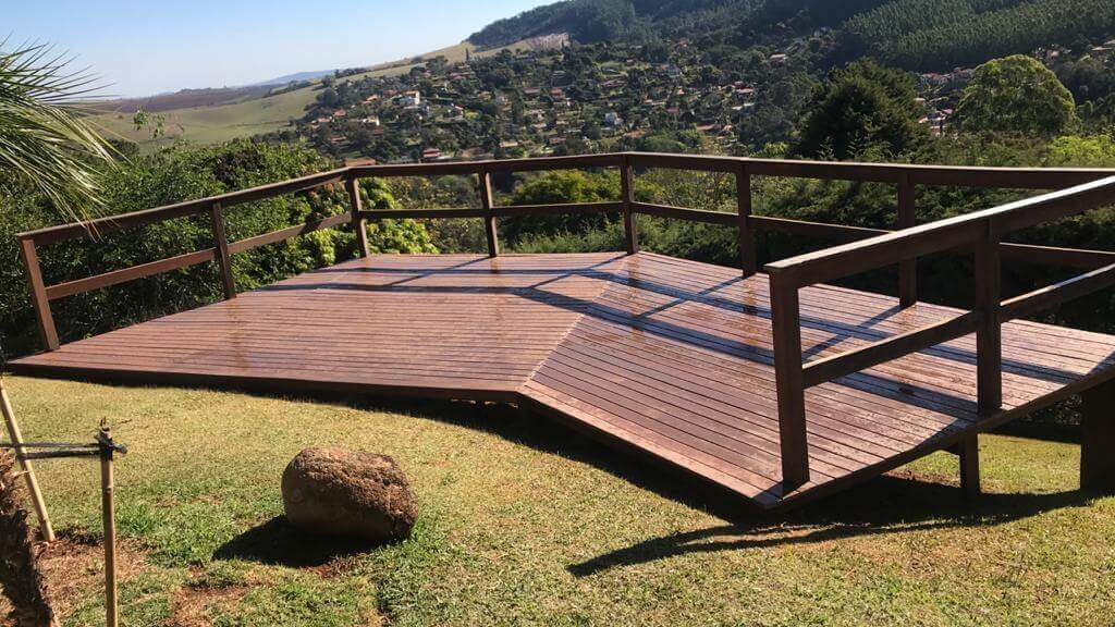 a wood deck with trees around and a panoramic view of a city.